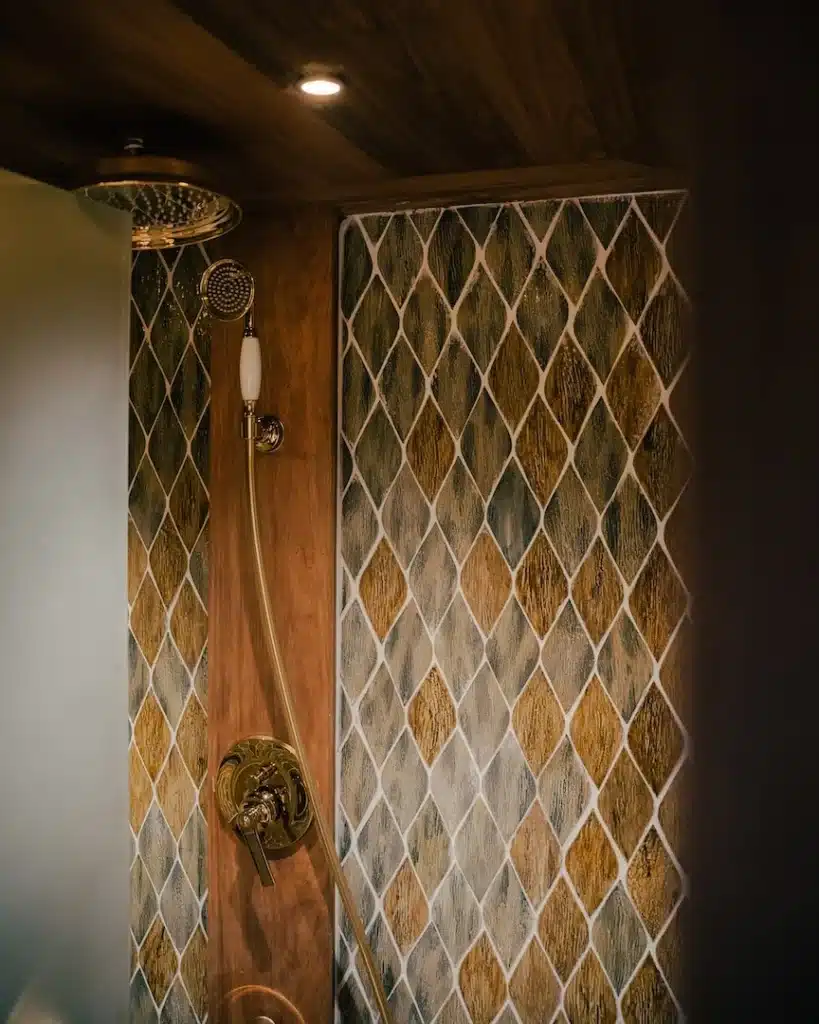 Onboard rain shower with gold fittings and diamond mosaic tile wall